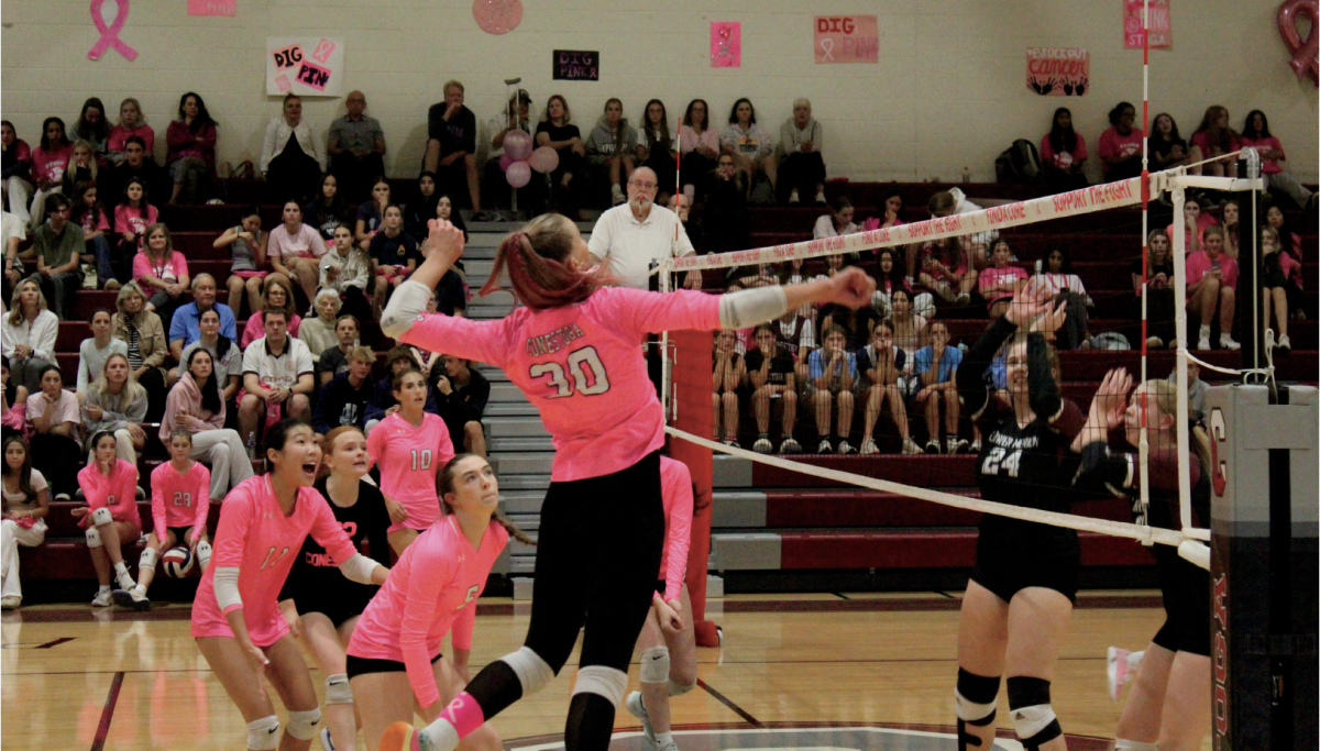 Playing in pink: Senior Cheyenne Bird strikes the ball during a match against Lower Merion. On Oct. 7, the Conestoga girls’ volleyball team held a “Dig Pink” event to raise breast cancer awareness through various raffles and bake sales while the girls played on the court. 